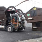 Front-Load Truck Emptying Container in the Greater Boston area